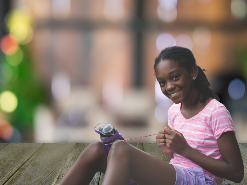 Girl at summer camp making a bracelet