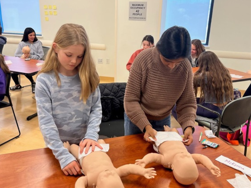 Tweens learning how to change a diaper