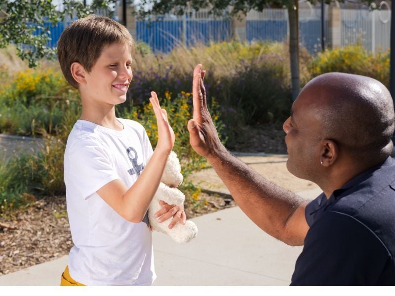 adult and kid high fiving
