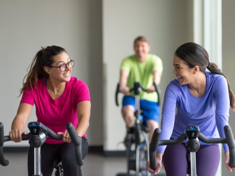 Two women on exercise bikes