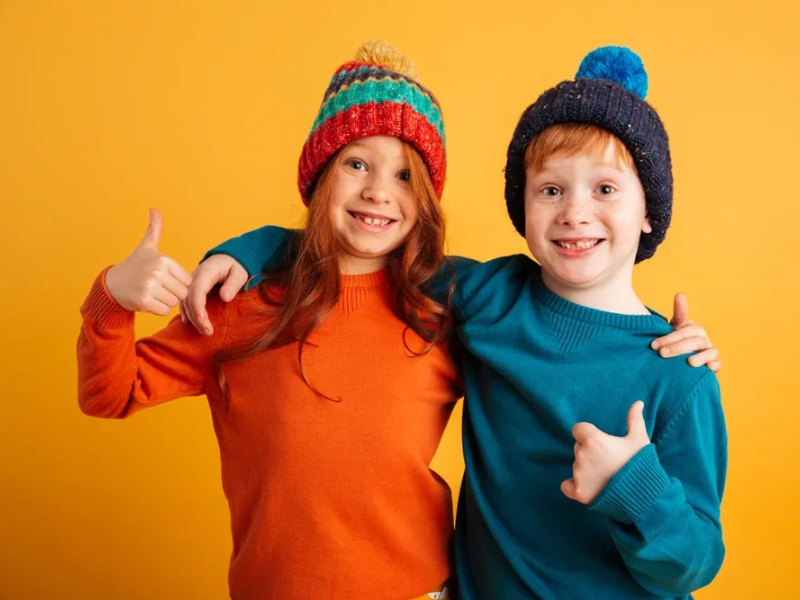 Kids in winter hats giving thumbs up