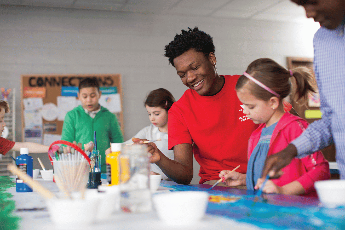 YMCA staff member helping kids 