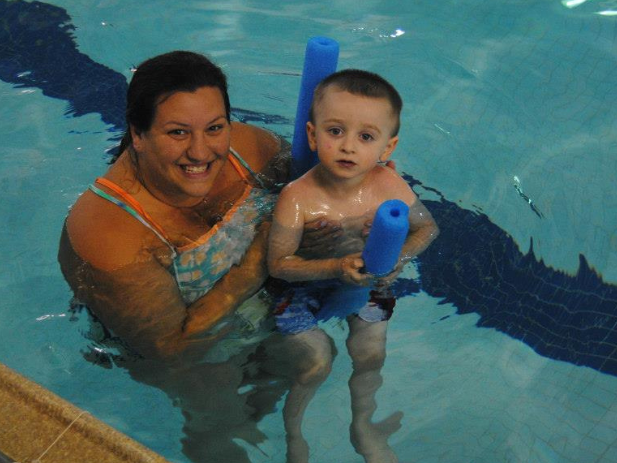 A mom and her son with a pool noodle in the pool at the YMCAs Safety Around Water week