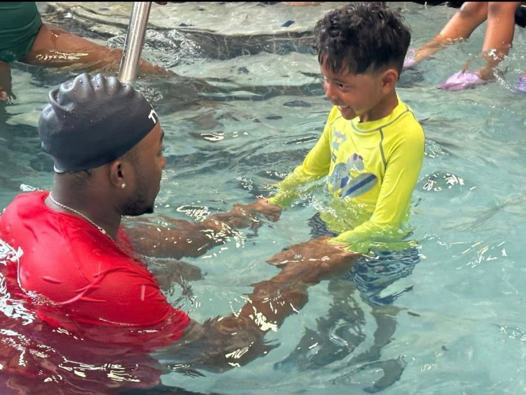 A YMCA instructor helping a child in the pool at Safety Around Water week