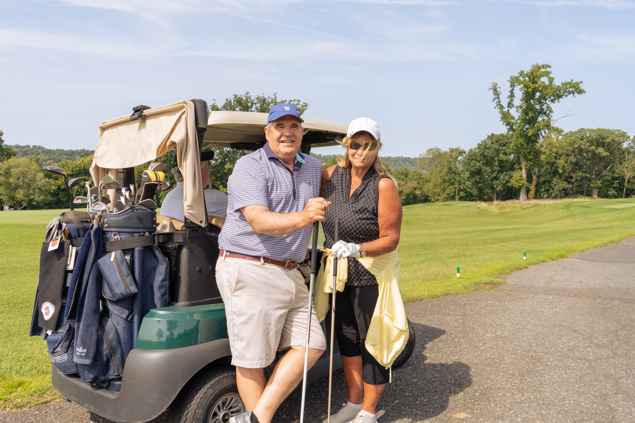 Two golfers posing outside their golf cart at the Sussex County YMCA Golf Outing