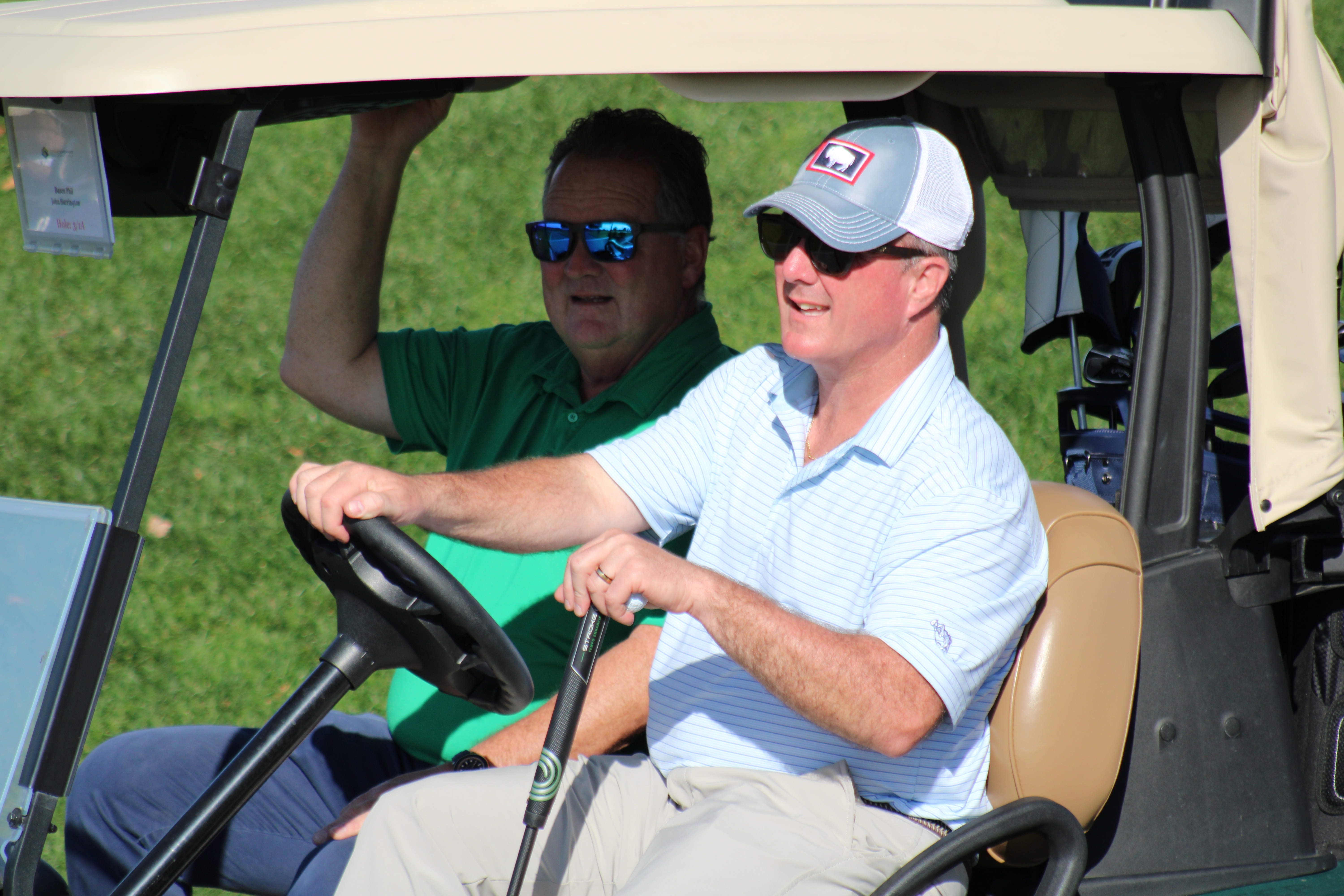A golf team riding in a golf cart at the Metro YMCA Golf Outing in New Jersey