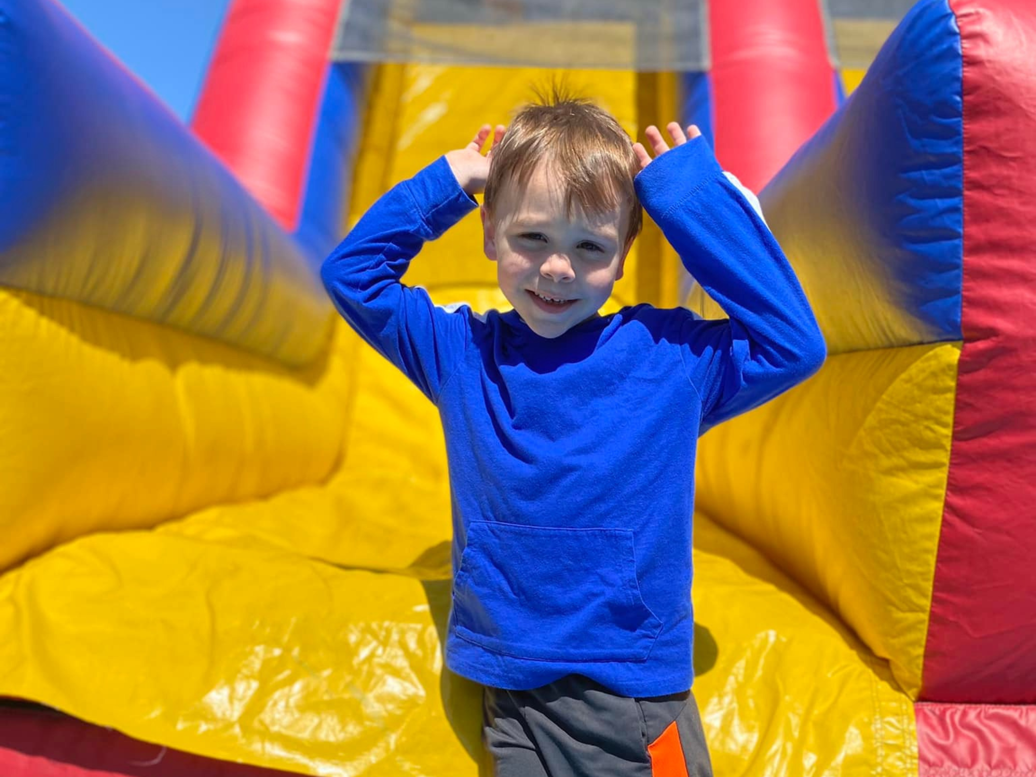 Little boy going down a blow up slide at Healthy Kids Day